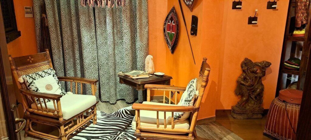 Recibidor con mesita y dos sillas habitación África