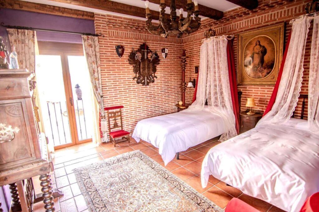 Habitación España con dos camas individuales decorada estilo castellano. Casa del trotamundos
